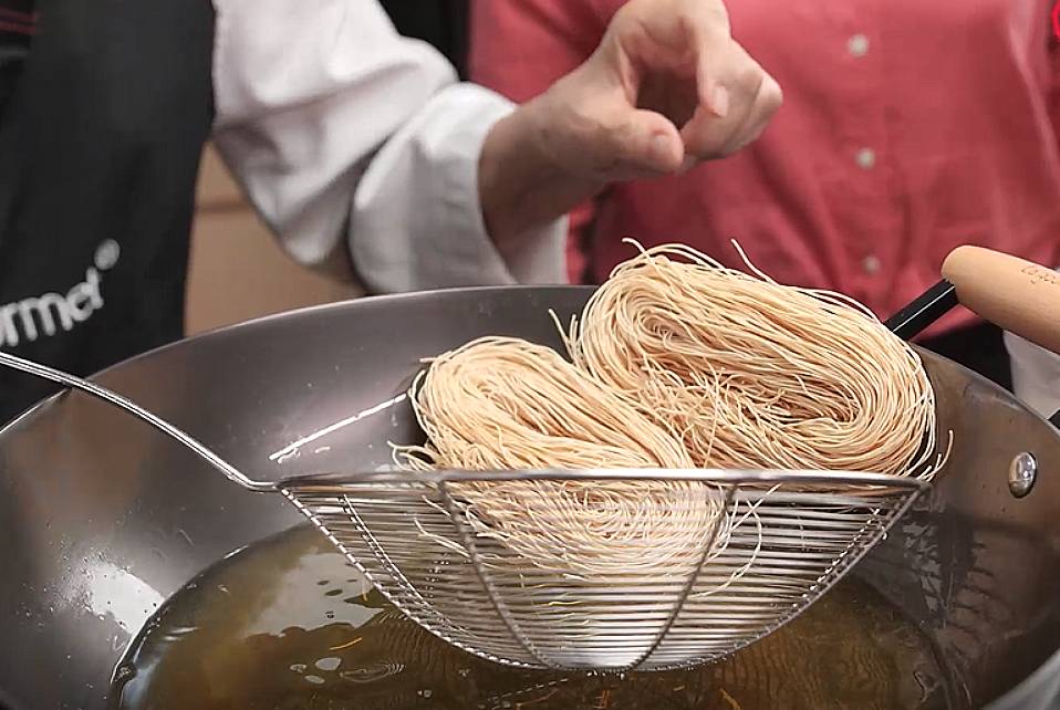transfer the fried noodles to the boiling water for soaking process